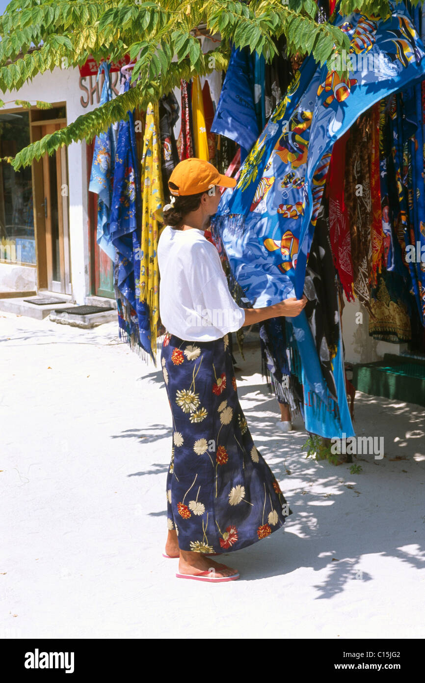Donna shopping per gli asciugamani da spiaggia, Maldive, Oceano Indiano Foto Stock
