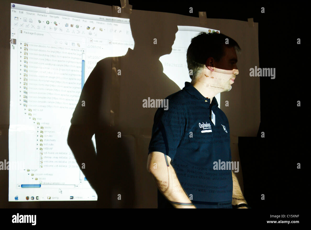 Uno sviluppatore di software è evidenziato dal suo proprio codice di programma come egli è di spiegare in una presentazione. Foto Stock