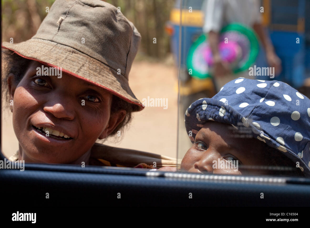 La madre e il bambino. Guardando attraverso un finestrino del veicolo. Mendicare per acqua potabile. supplica con i turisti in un'auto.Madagascar. Foto Stock