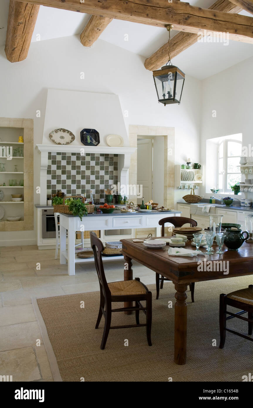 Cucina provenzale con soffitto con travi a vista e tavolo da pranzo in legno Foto Stock