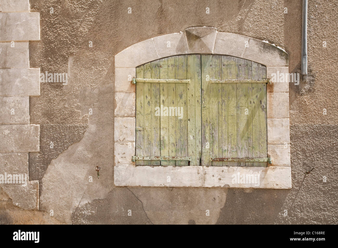 Dettaglio di un antico muro di pietra in Francia con una tradizionale finestra chiuse Foto Stock