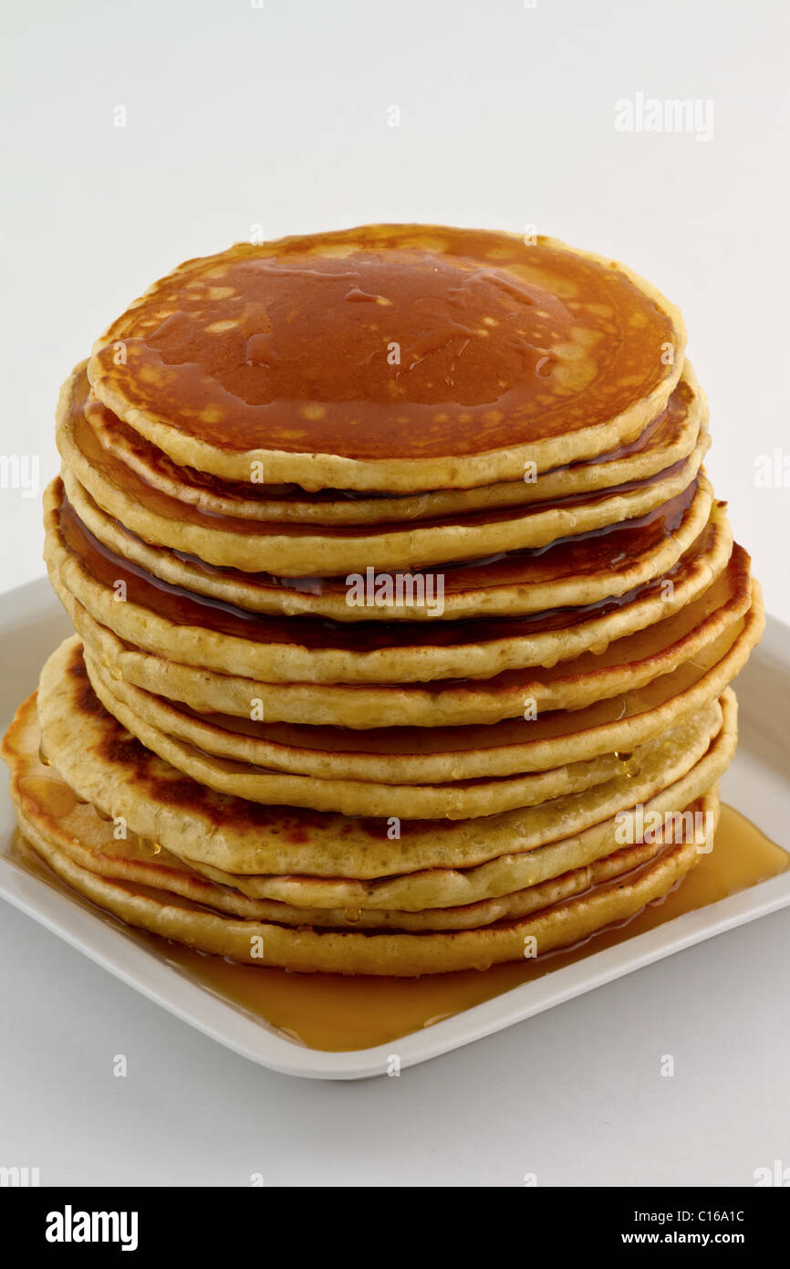 Pila di Pancake fatti in casa con sciroppo su una piastra bianca. Foto Stock