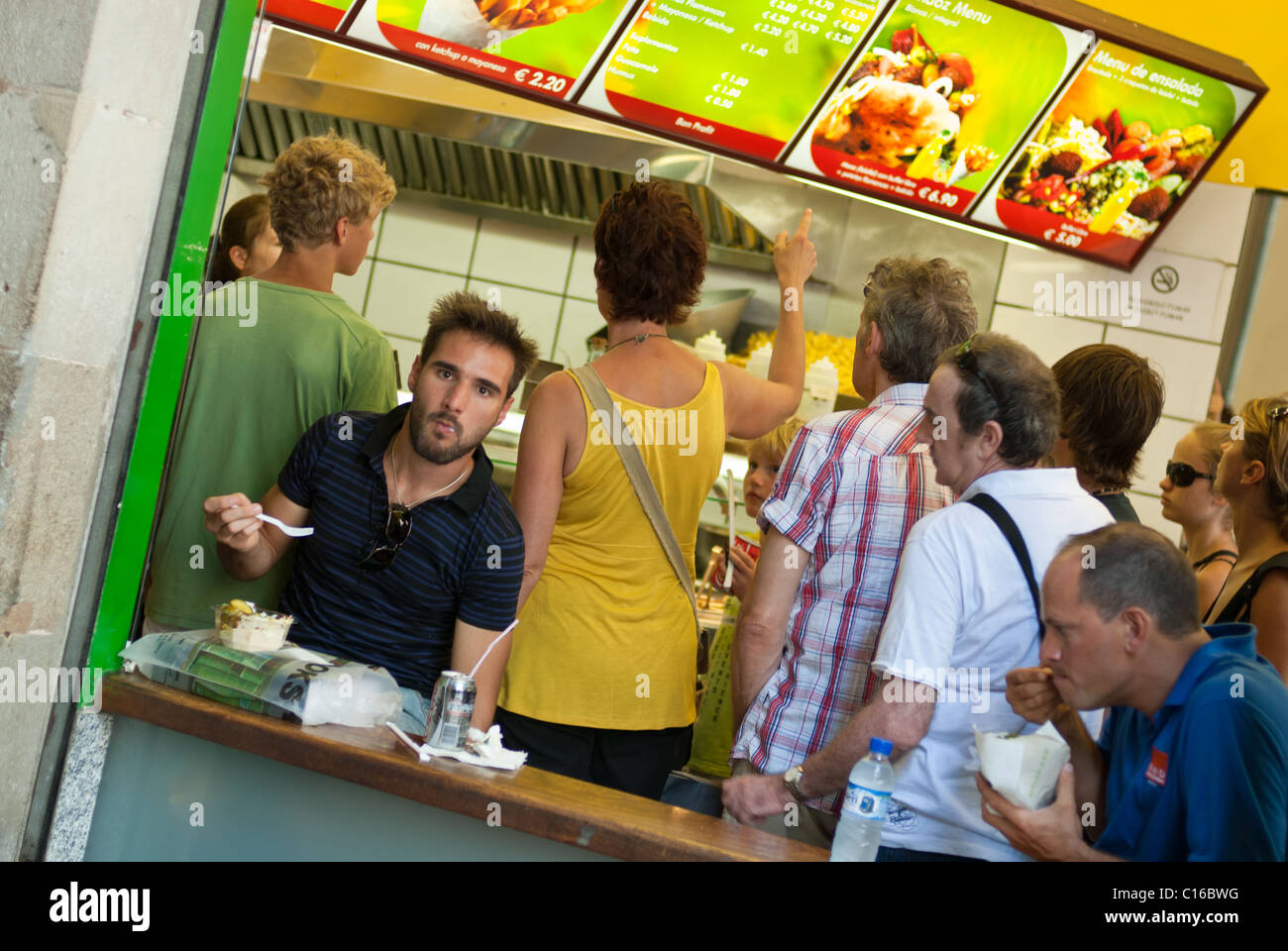Barcellona, Spagna - Luglio 28, 2008: persone baying e mangiare cibo spazzatura al piccolo bar sulla strada della Ramblas. Foto Stock