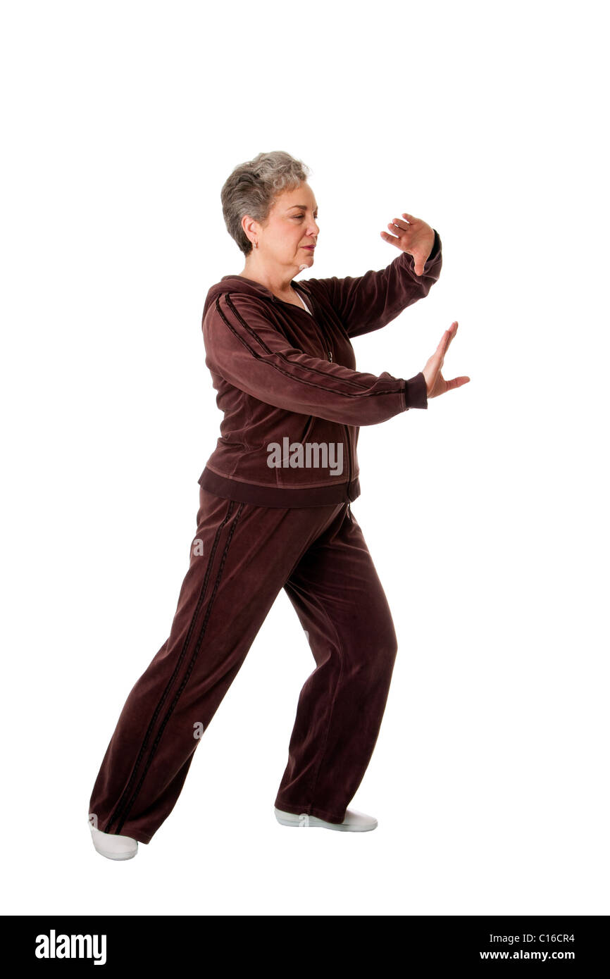 Bella donna Senior facendo Tai Chi esercizio per tenere la sua articolazioni flessibile, isolata. Foto Stock