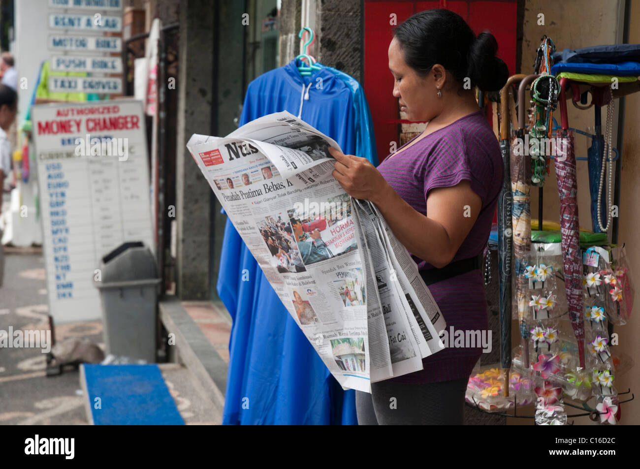 Persona Balinese leggendo un quotidiano Foto Stock
