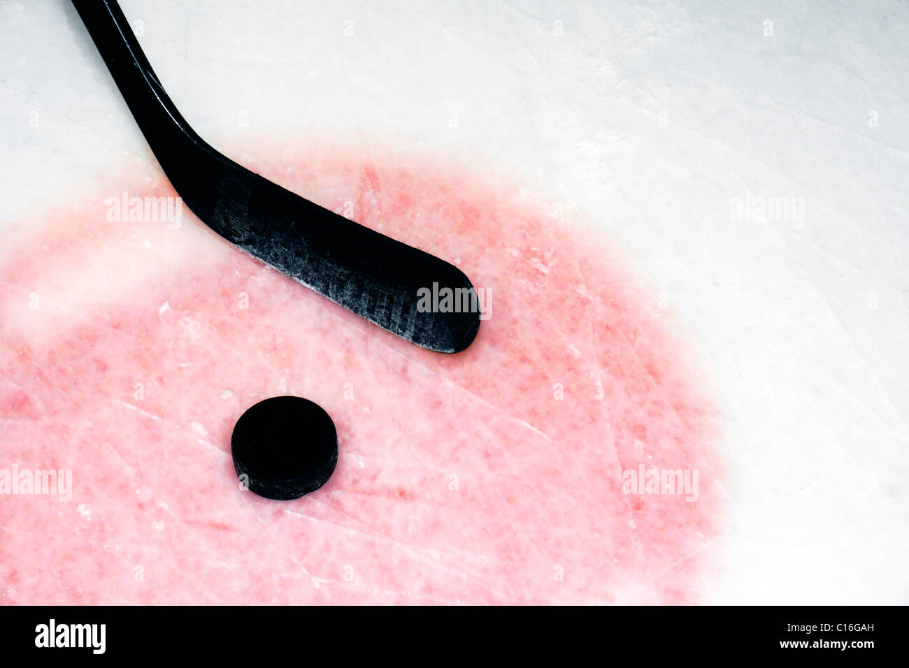 Hockey sport background: stick in grafite e puck su real arena utilizzato e graffiato il ghiaccio. Foto Stock