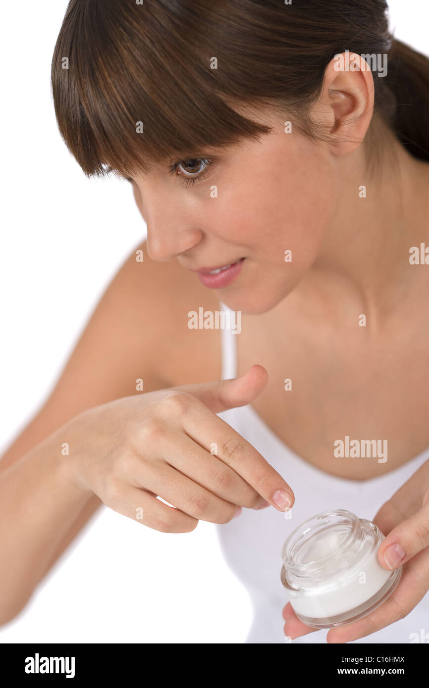 Cura del corpo - adolescente di sesso femminile di applicare una crema idratante crema sulla faccia Foto Stock