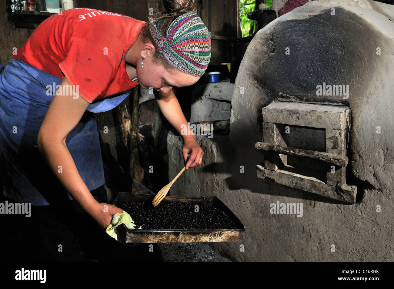 Giovane donna torrefazione di caffè in un risparmio di energia forno a legna, Miraflor-Moropotente Riserva Naturale, Esteli, Nicaragua Foto Stock