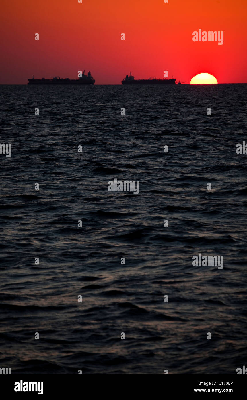 Energia solare o olio? Le petroliere e barca da pesca off Galveston in Texas, nel Golfo del Messico, al tramonto Foto Stock