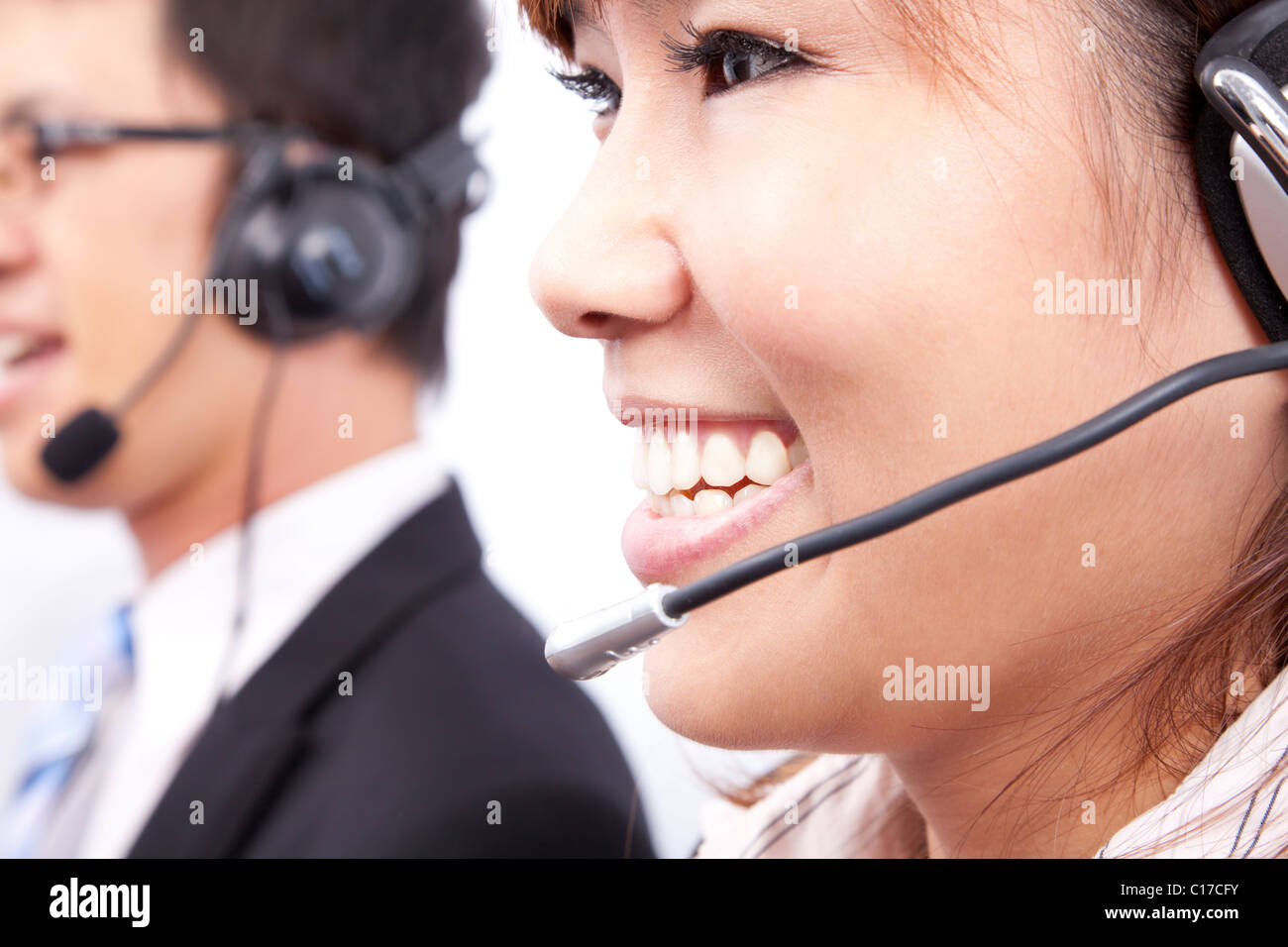 Team di assistenza clienti con imprenditrice sorridente in ufficio Foto Stock
