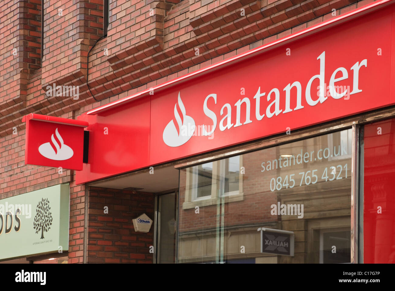 Banca Santander logo e segno al di sopra del ramo locale finestra anteriore a Wrexham, il Galles del Nord, Regno Unito, Gran Bretagna Foto Stock