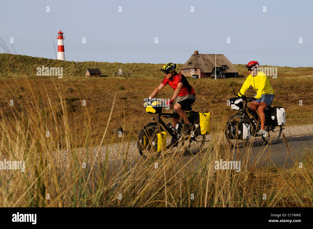 I ciclisti nella parte anteriore del faro Ostellenbogen, Sylt, Frisia settentrionale, il Mare del Nord, Schleswig-Holstein, Germania, Europa Foto Stock