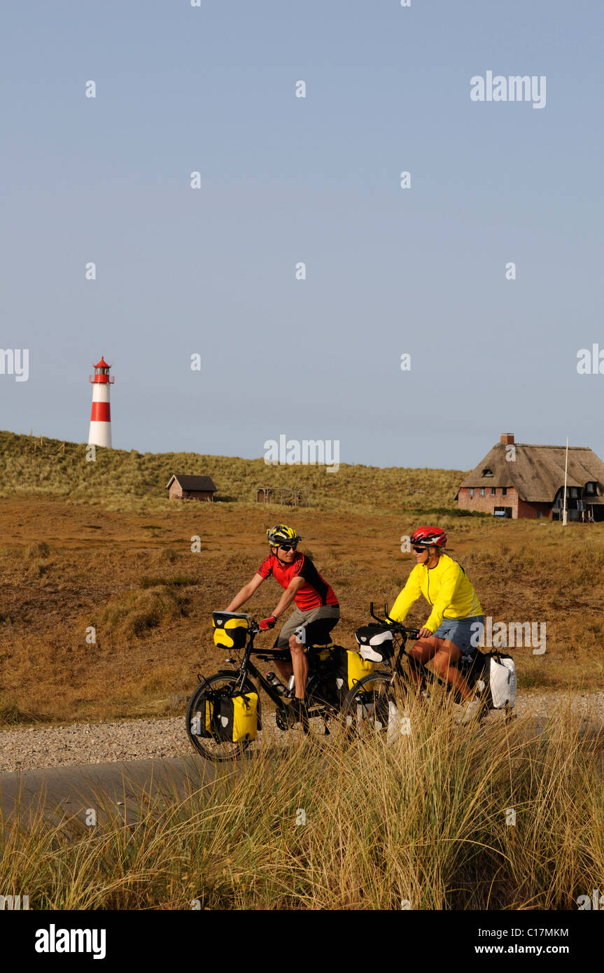 I ciclisti nella parte anteriore del faro Ostellenbogen, Sylt, Frisia settentrionale, il Mare del Nord, Schleswig-Holstein, Germania, Europa Foto Stock