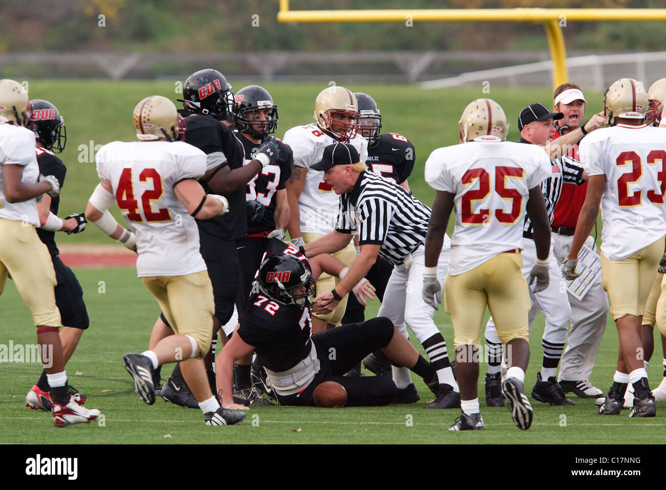 Gli arbitri di tentare di rompere un alterco tra università cattolica e Bridgewater College giocatori durante una partita di calcio. Foto Stock