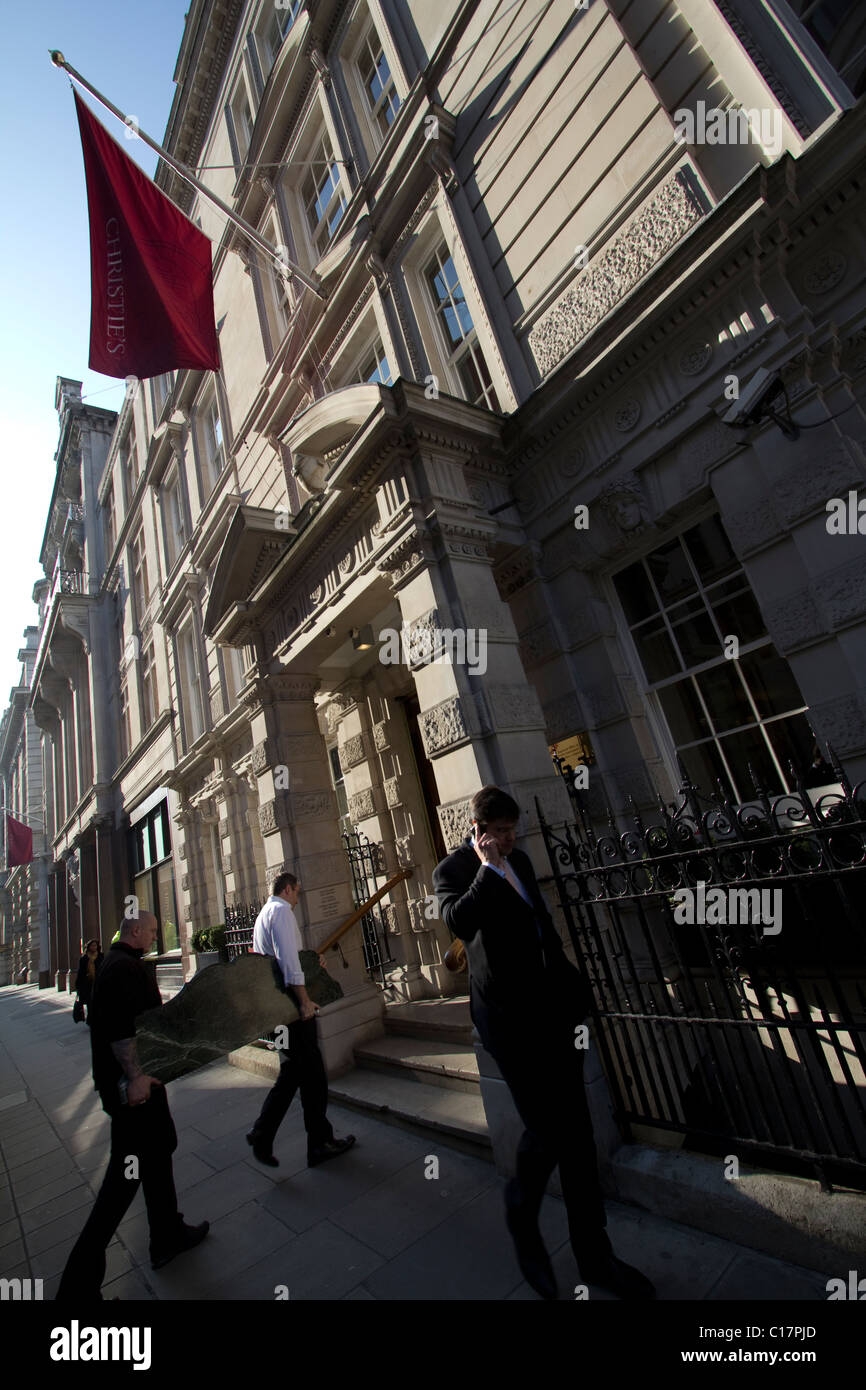 Facchini che trasportano opere d'arte attraverso l'ingresso anteriore della casa d'aste di Christie, Londra, Regno Unito Foto Stock