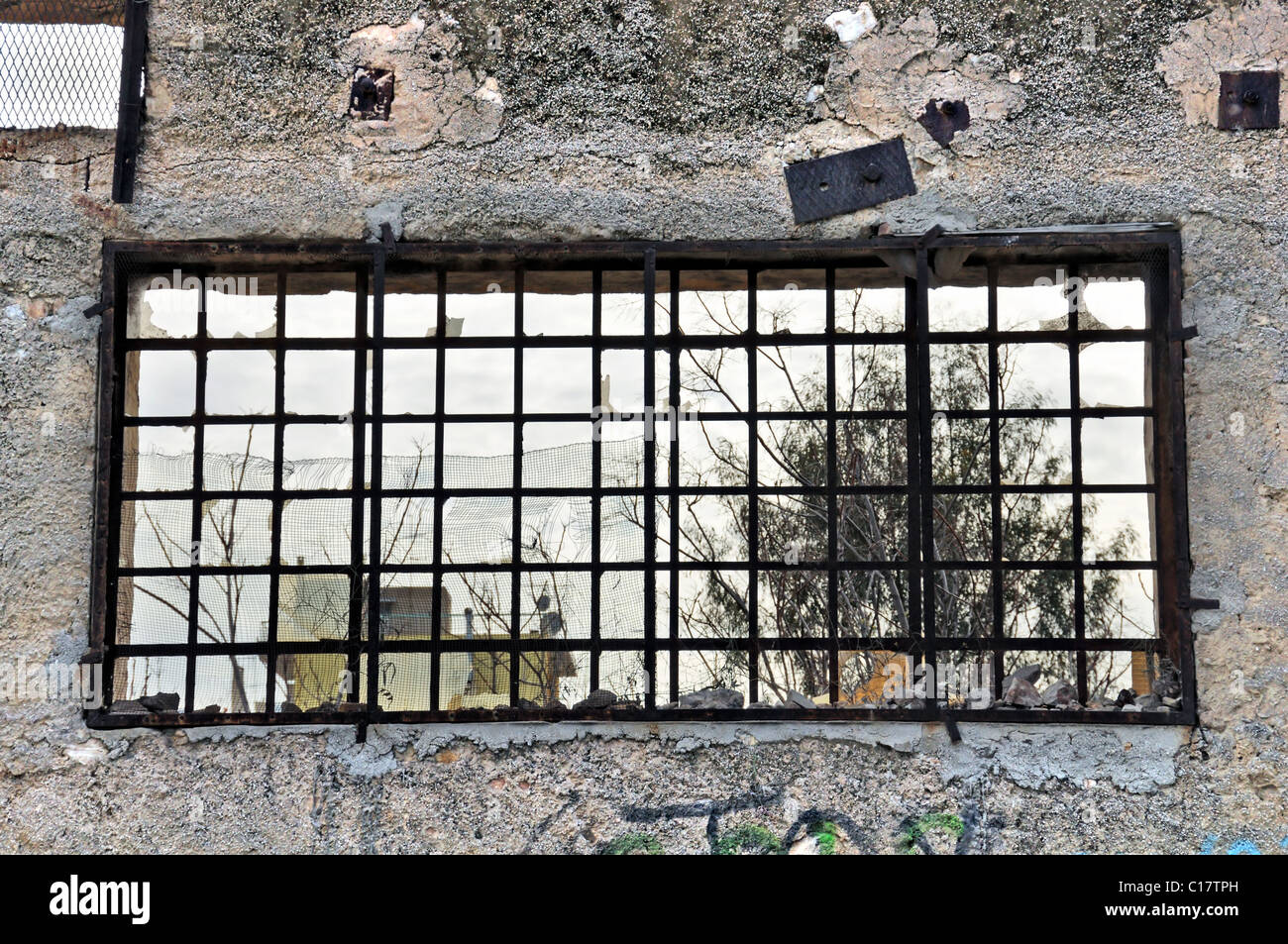 Parete in cemento e la vista dalla finestra rotta di fabbrica abbandonata. Foto Stock