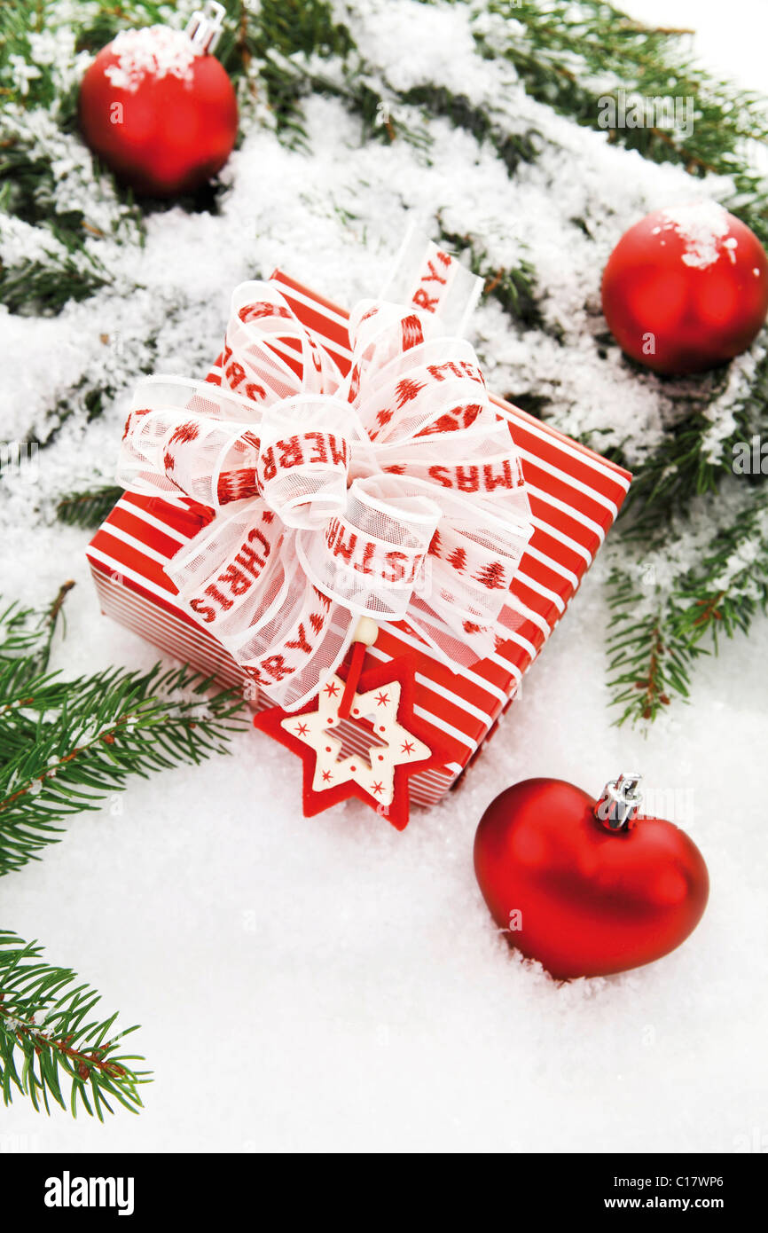 Regalo di natale con rami di abete, a forma di cuore ad albero di Natale baubles e decorazioni sulla neve Foto Stock