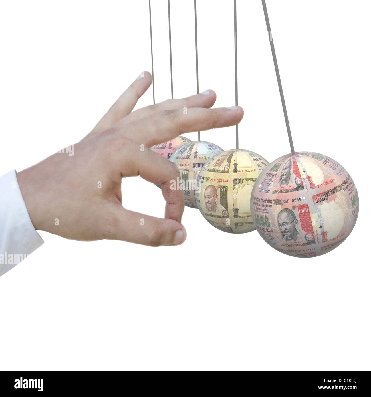 Mano umana che colpisce il denaro pendoli in una culla Foto Stock