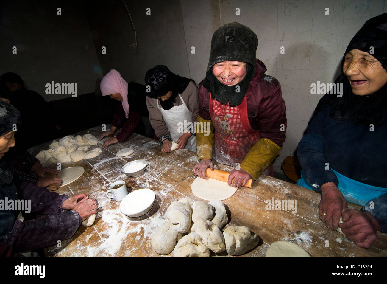 Hui musulmani la cottura di un piatto tradizionale pane in un piccolo panificio della città vecchia di Linxia, Gansu. Foto Stock