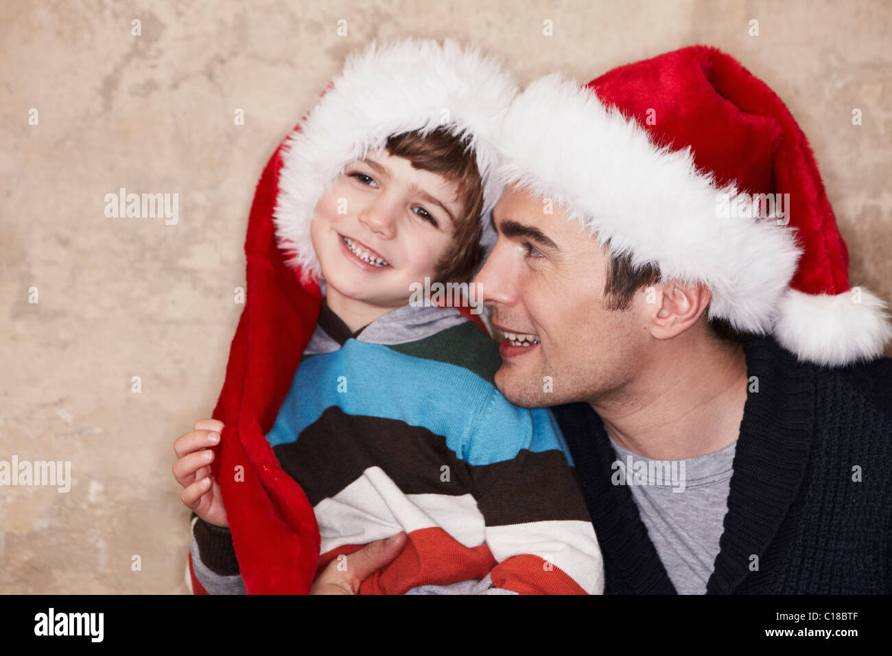 Padre e figlio indossando cappelli di Babbo Natale Foto Stock