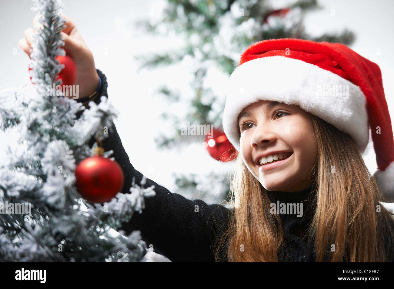 Ragazza decorare l'albero di Natale Foto Stock