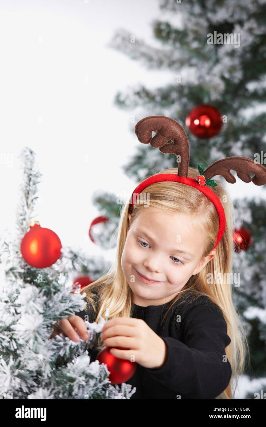 Ragazza decorare un albero di Natale Foto Stock