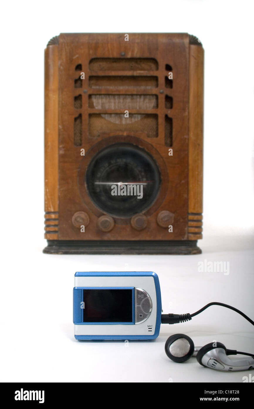 Un nuovo lettore mp3 e le cuffie con un vecchio retro vintage legno radio  in background. Girato su sfondo bianco Foto stock - Alamy