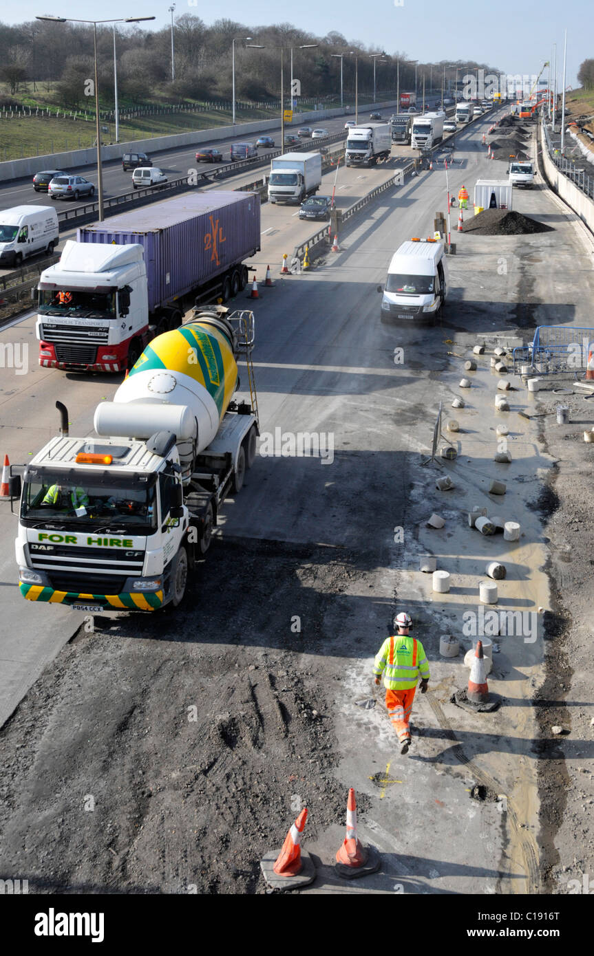 Vista dall'alto traffico e betoniera pronta per l'uso camion cantiere di ingegneria civile lavori di costruzione ampliamento della strada autostrada M25 Essex Inghilterra Regno Unito Foto Stock