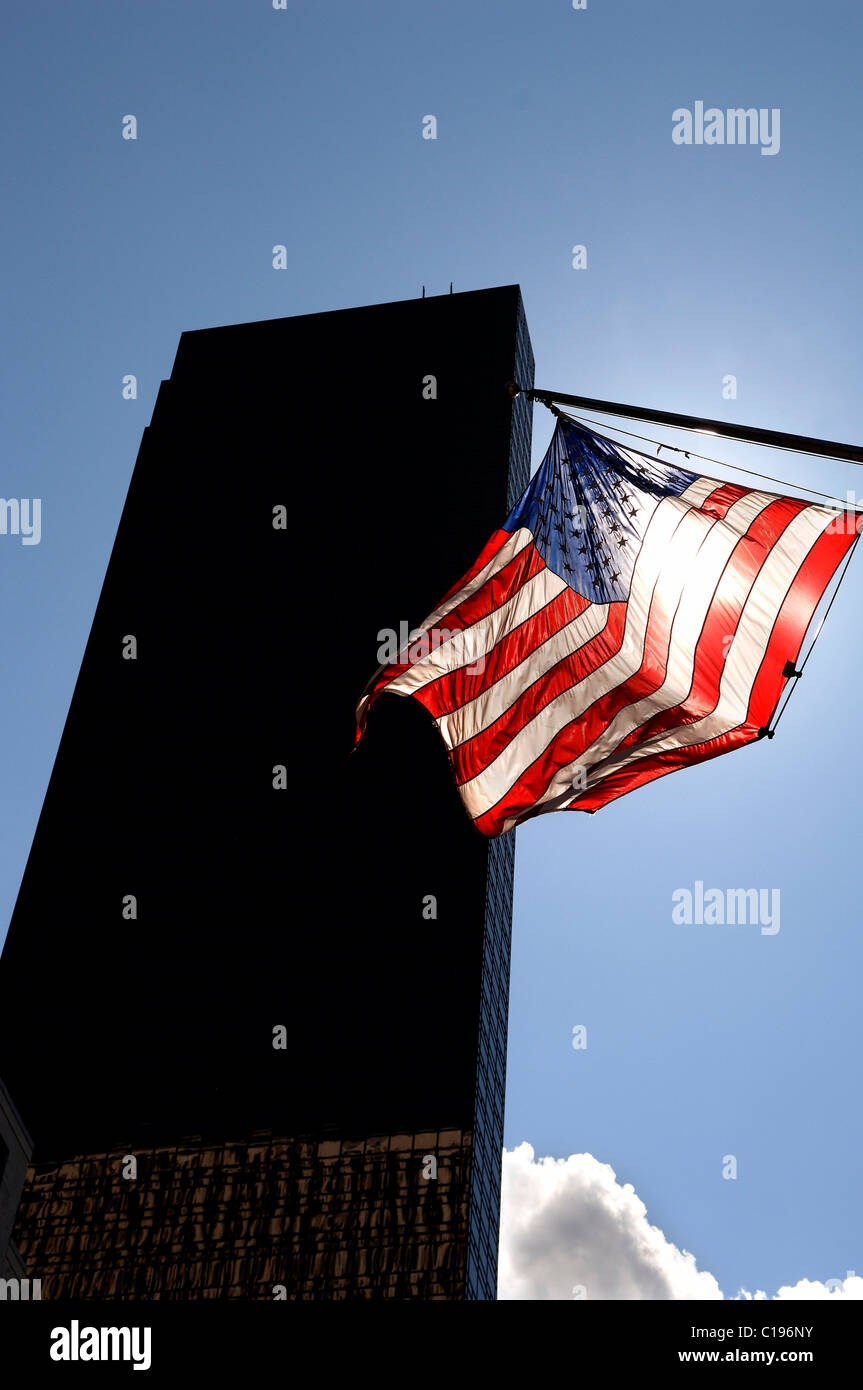 Grattacielo e US-bandiera con il sole che splende nel retro, New York City, Stati Uniti d'America Foto Stock