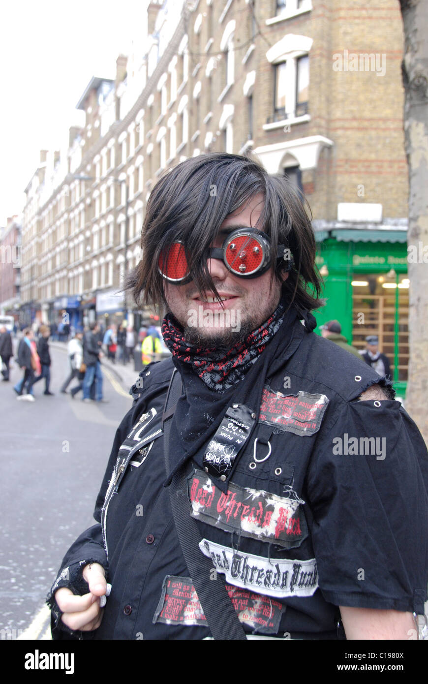 Outlandishly vestito giovane uomo forse un punk ' ' nel West End di Londra, con impossibilità di vedere attraverso sfumature. Foto Stock