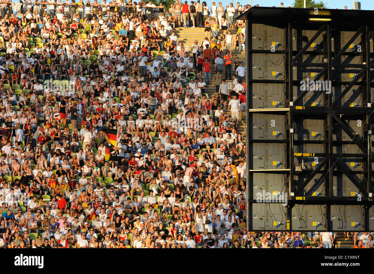 Un sacco di gente sulle tribune di fronte a uno schermo video durante una trasmissione di calcio presso lo Stadio Olimpico di Monaco di Baviera Foto Stock