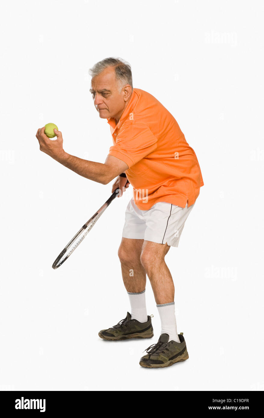 Uomo che serve una palla da tennis Foto Stock