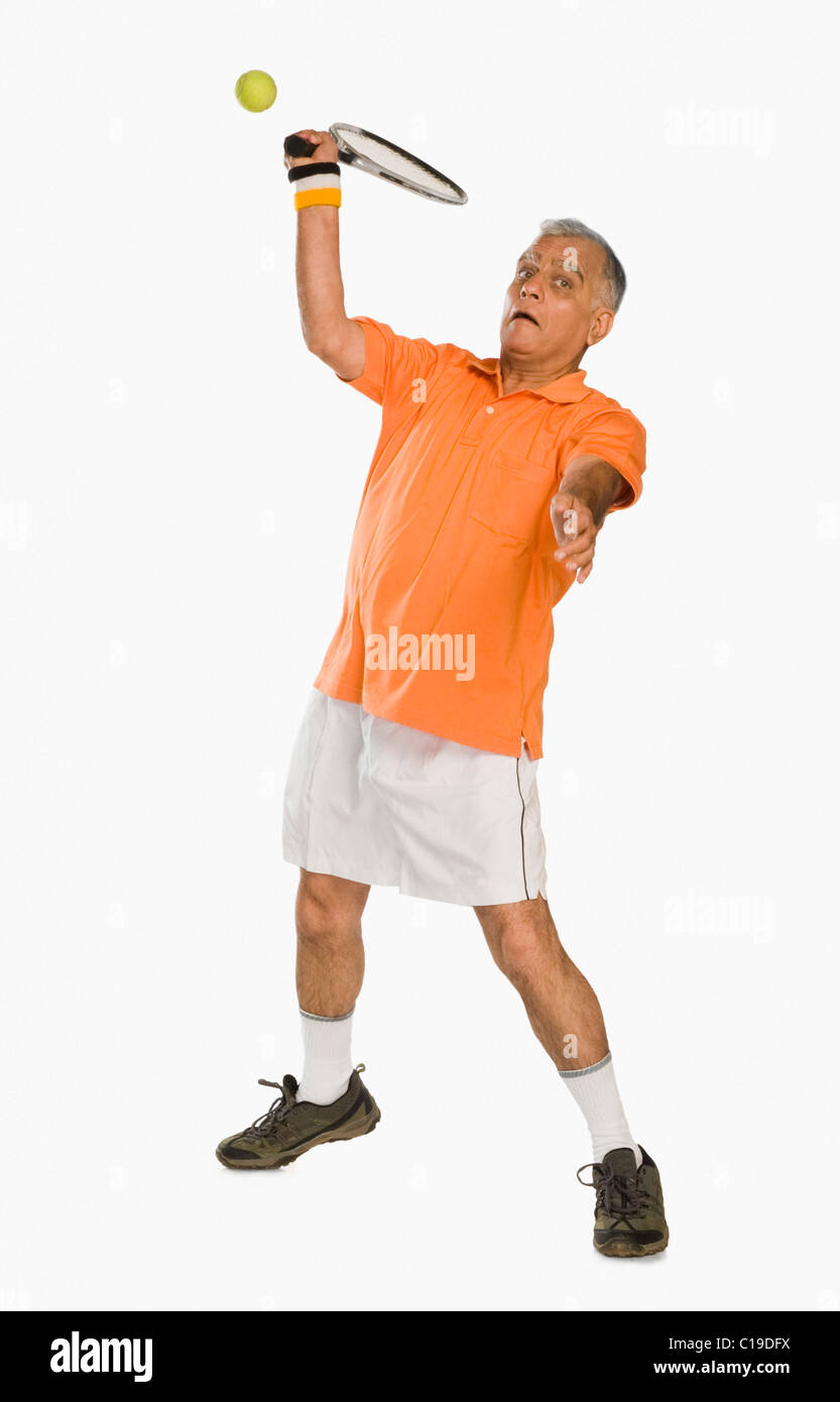 Uomo che serve una palla da tennis Foto Stock