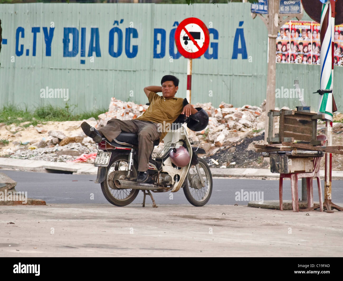 Poliziotto mentire indietro sul ciclomotore a guardia sonnolenta città del Vietnam street Foto Stock
