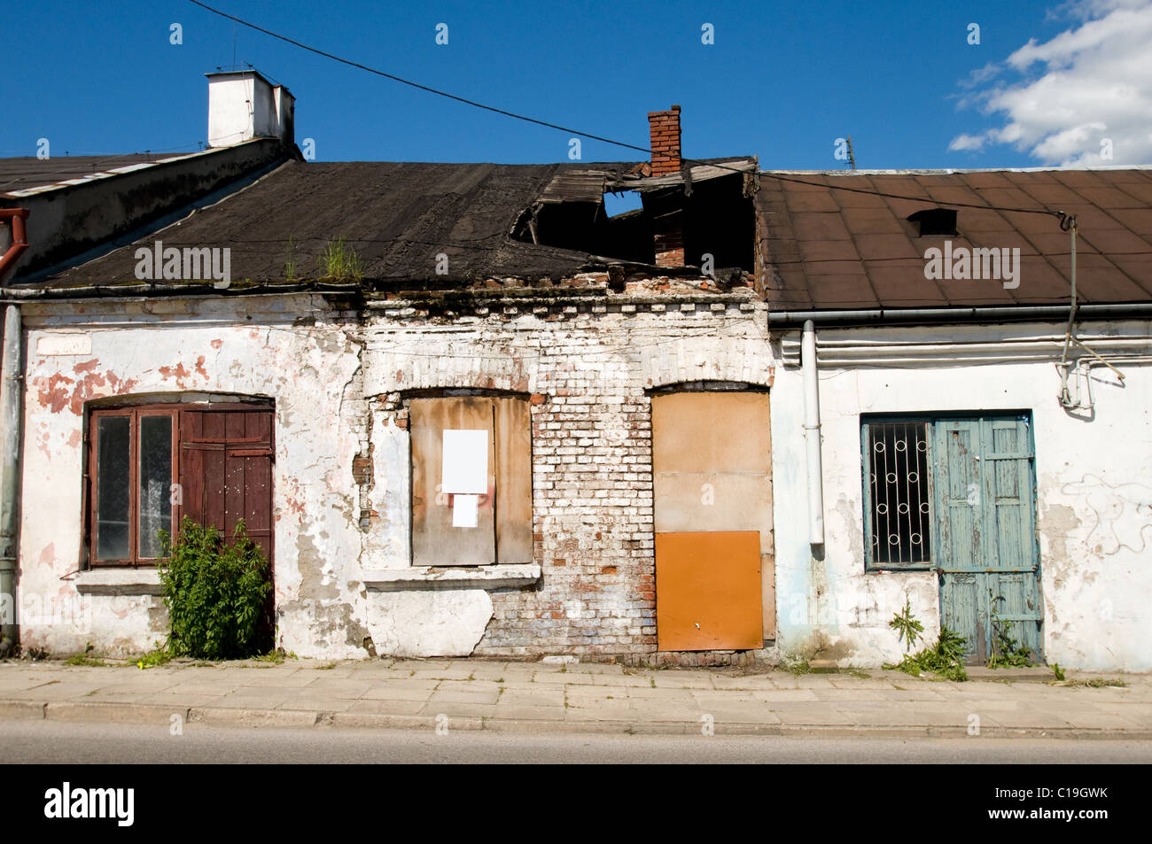 Danneggiato abbandonati cottage casa con il foro nel tetto Foto Stock