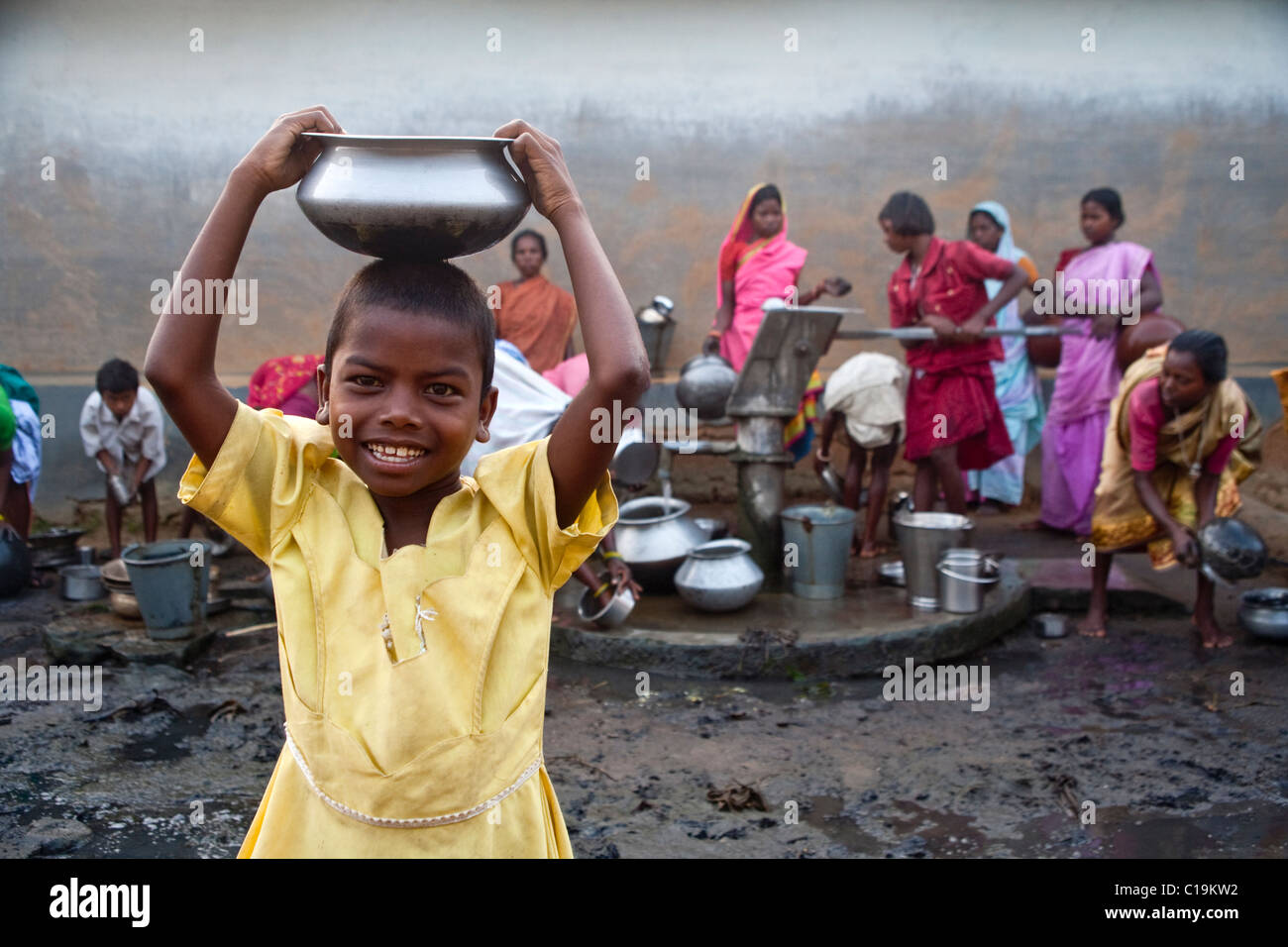 Ragazza porta una ciotola di acqua da un villaggio della pompa acqua nel Bengala occidentale, India Foto Stock