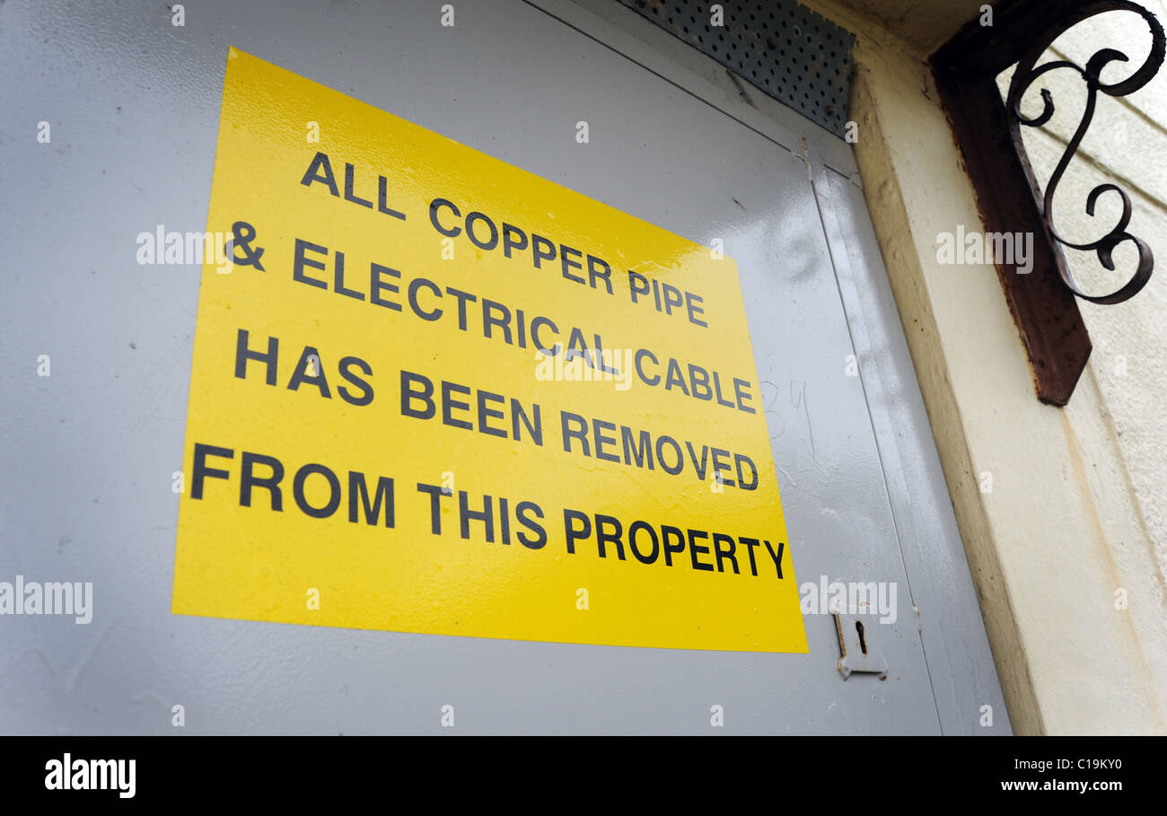 Comunicazione del Consiglio condannato sulla porta di casa dicendo ' tutto il cavo elettrico e il tubo in rame è stato rimosso da questa proprietà ' Regno Unito Foto Stock