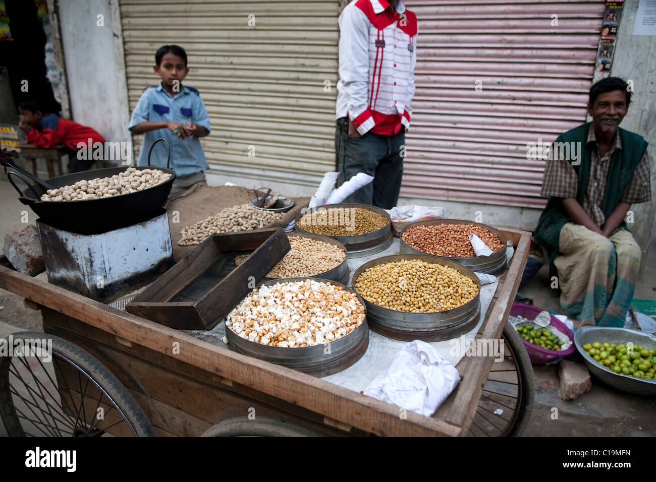 I venditori ambulanti vendono i dadi, popcorn, limette a Dhaka, nel Bangladesh. Foto Stock