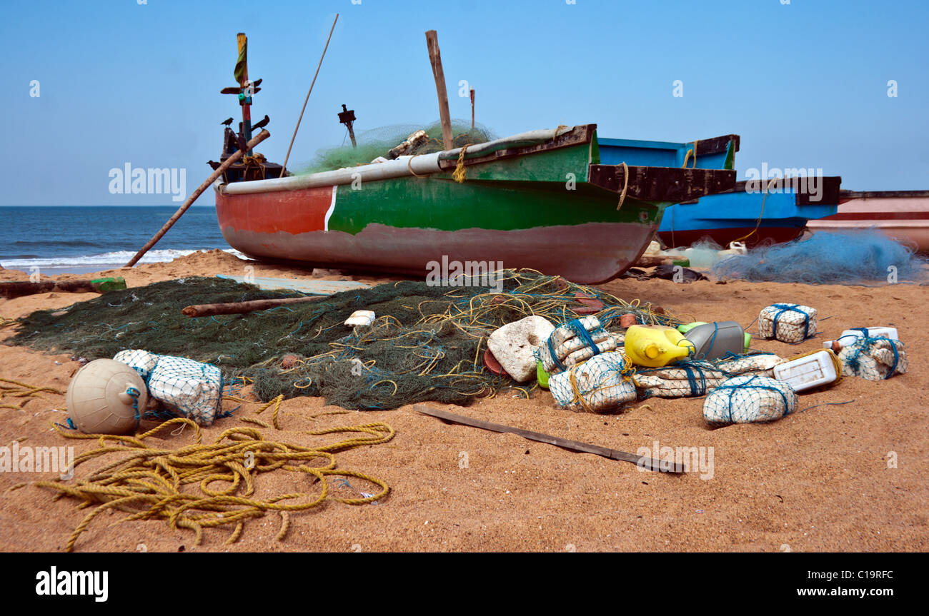 Fishermans barca e affrontare comprese reti a sinistra su una spiaggia per reti da traino successivo Foto Stock