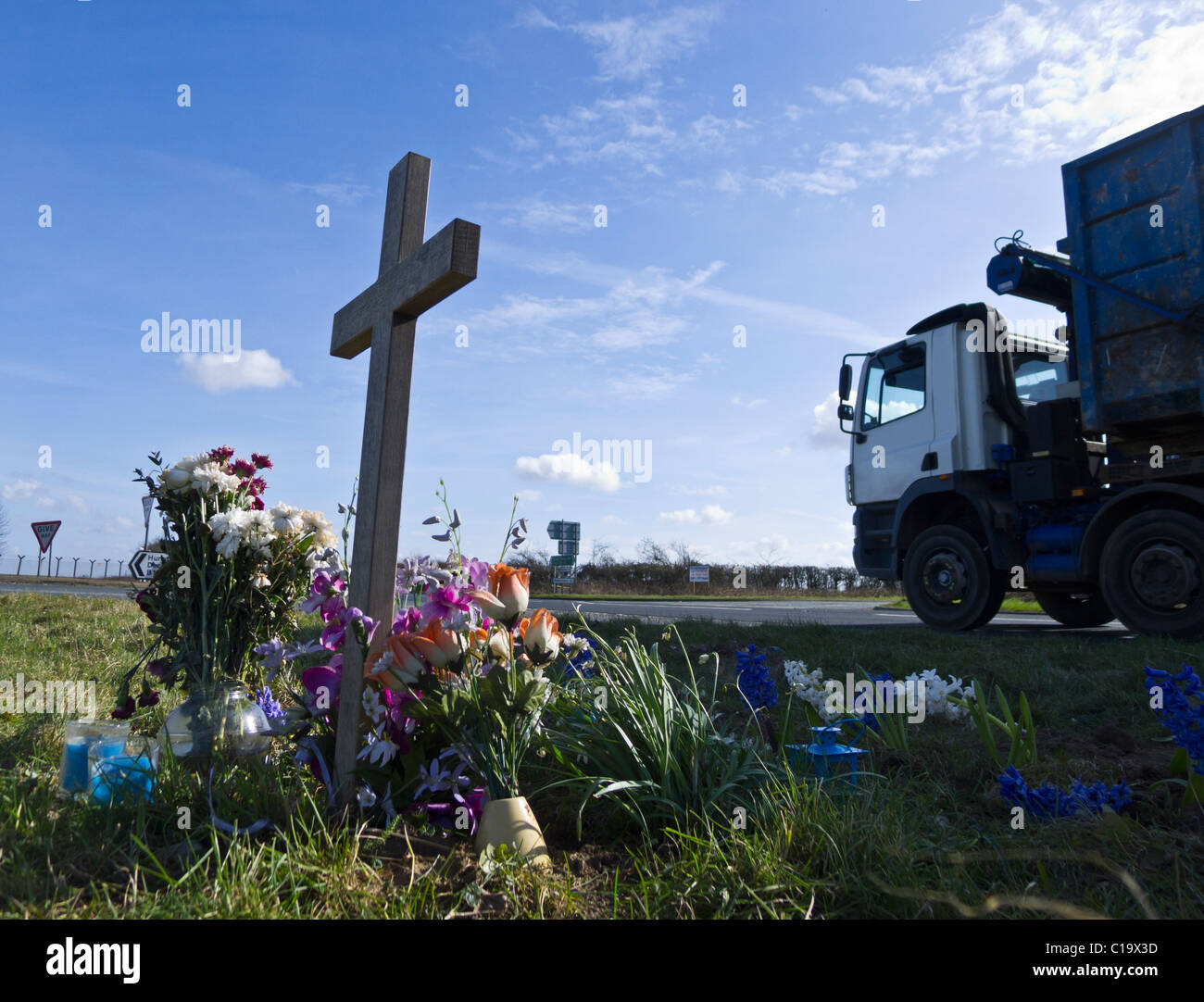 HGV passando un santuario di fortuna su una strada principale incidente blackspot. Foto Stock
