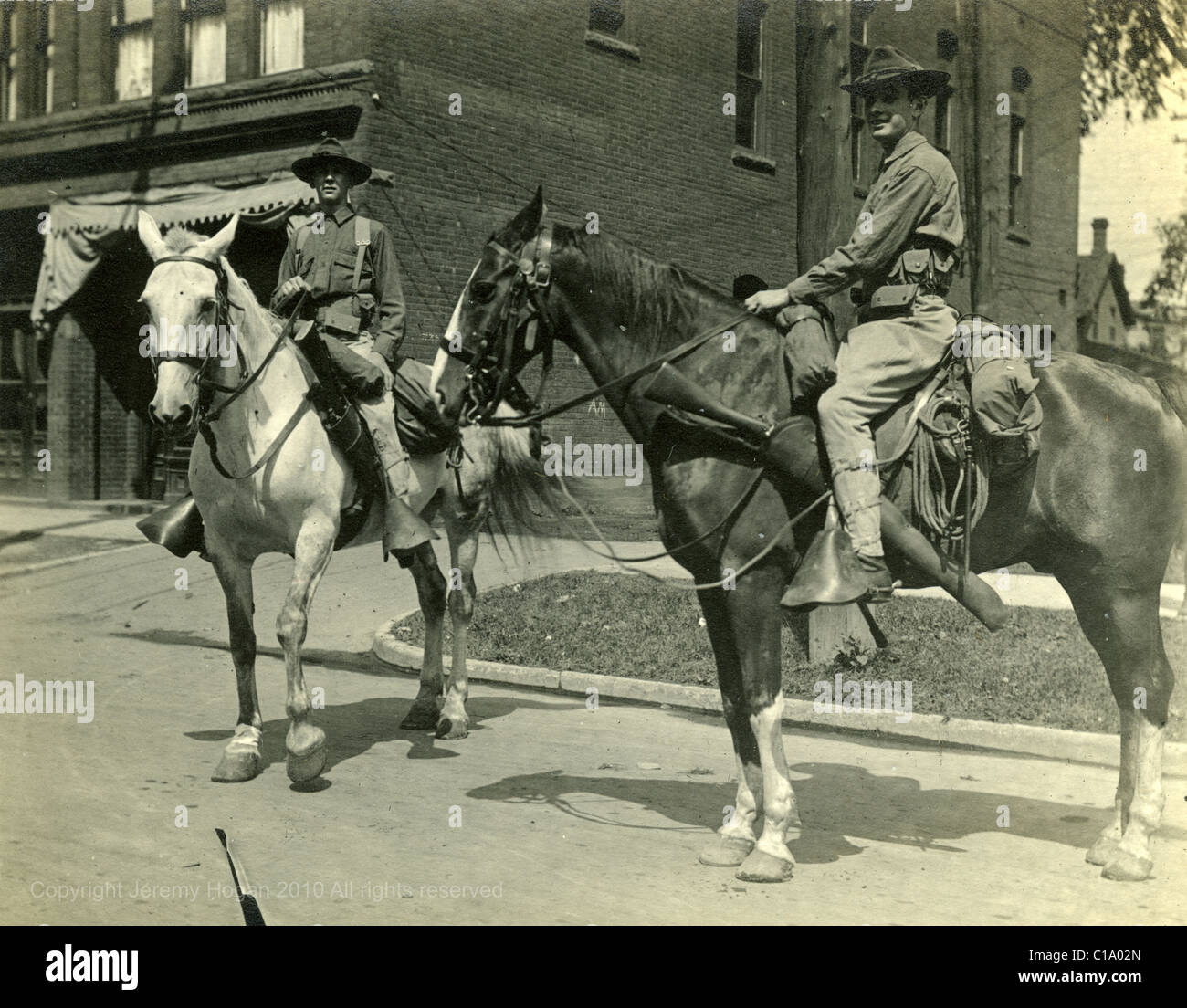 Cavalleggeri su cavalli sulla strada principale nella piccola cittadina americana 1910s uomini trasporto CAV i militari Foto Stock