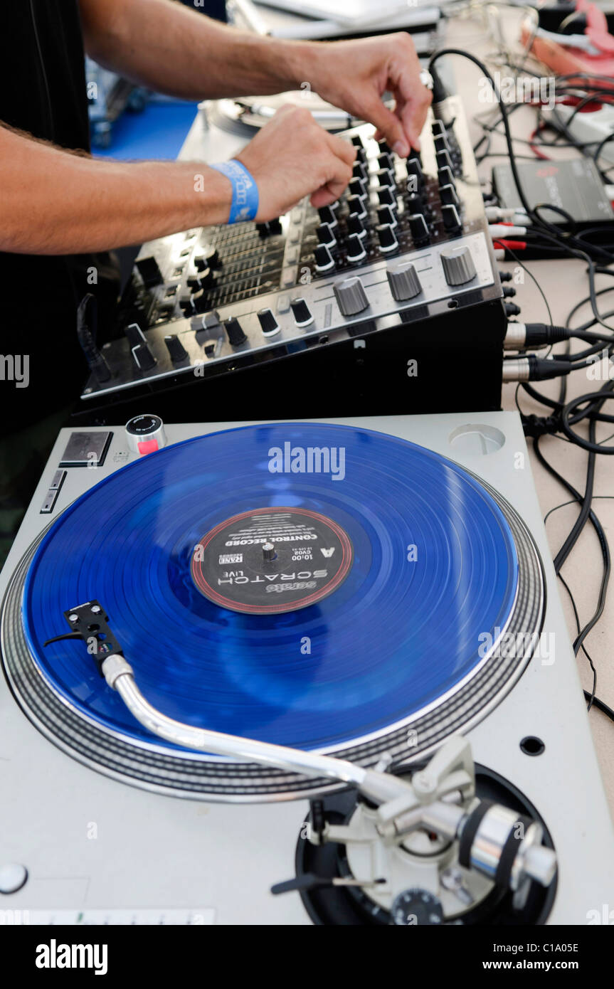 Il mixaggio DJ Mixer usando blu e graffiare dischi in vinile Foto stock -  Alamy