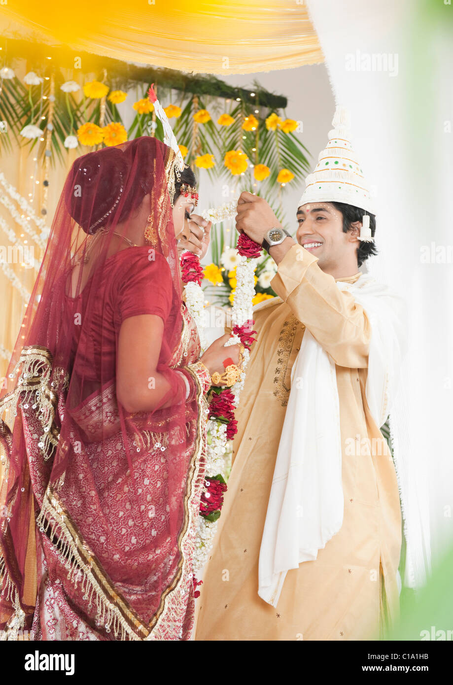 Paio di eseguire la mala (Badal Garland scambiare) cerimonia di nozze in Bengali Foto Stock