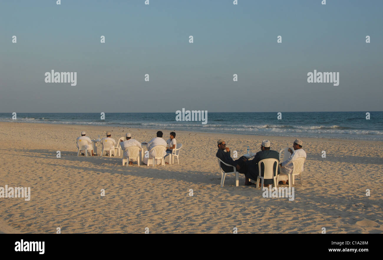 Omanis rilassarsi con drink su Indian Ocean Beach a Salalah, Southern Oman Foto Stock