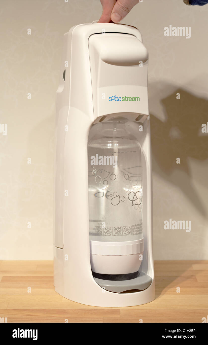 Mano premendo il pulsante iniettare anidride carbonica in acqua in sodastream home bevande analcoliche gassate maker equivalente moderno Foto Stock