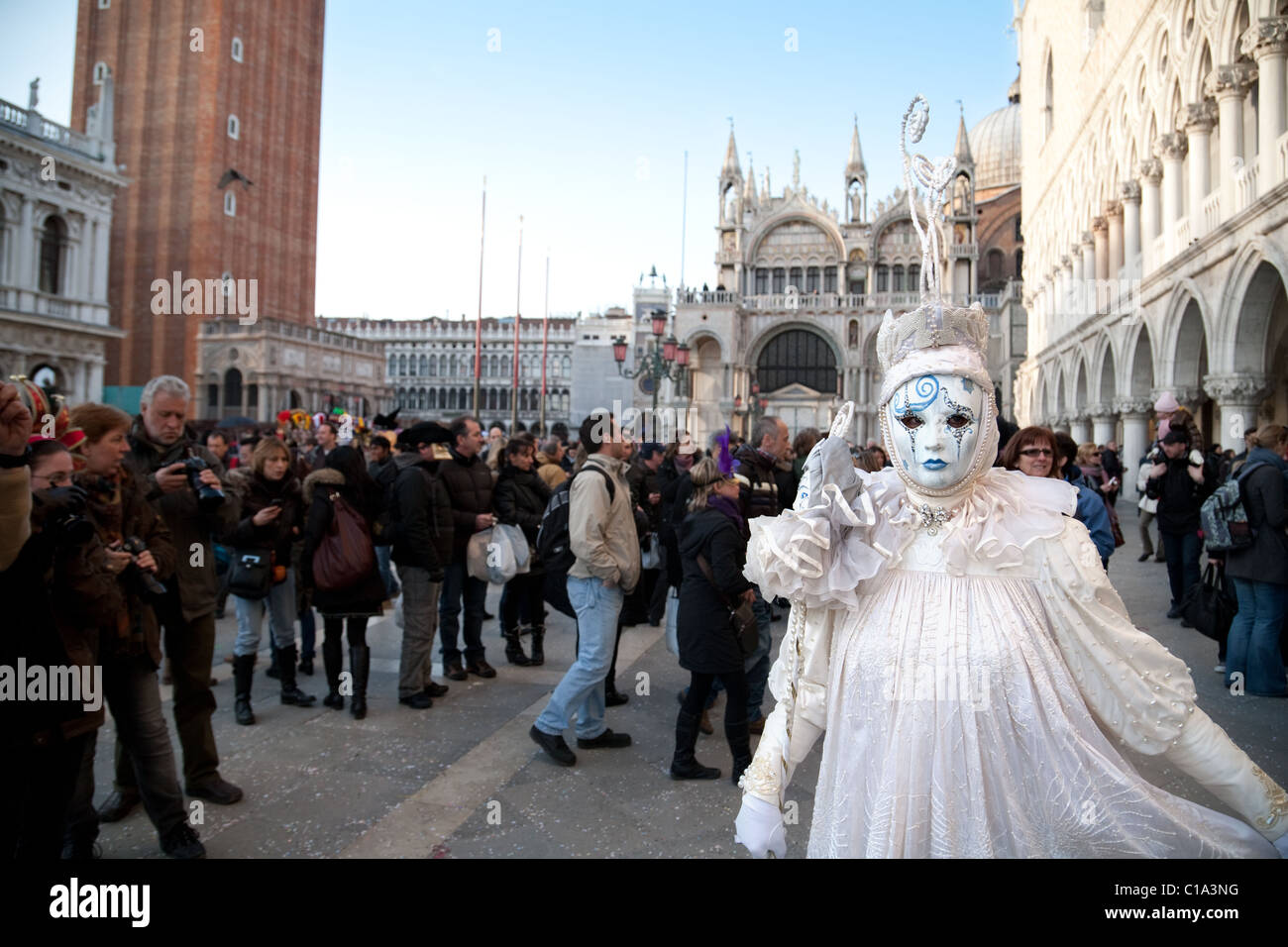 Un modello di posa per la folla in piazza San Marco, il carnevale di Venezia, Venezia Italia Foto Stock