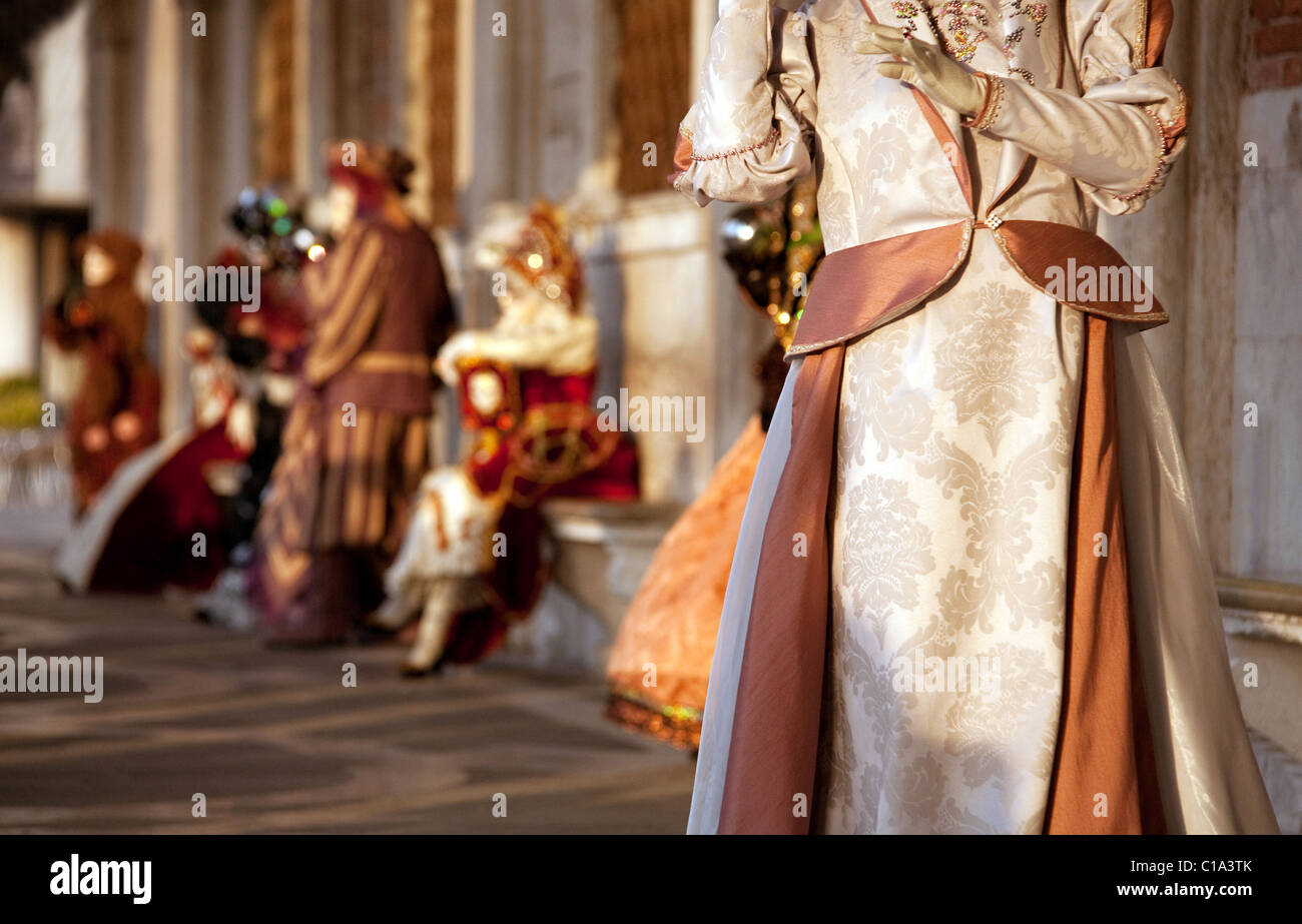 Masqueraders ponendo sotto gli archi in piazza San Marco , il carnevale di Venezia, Venezia Italia Foto Stock