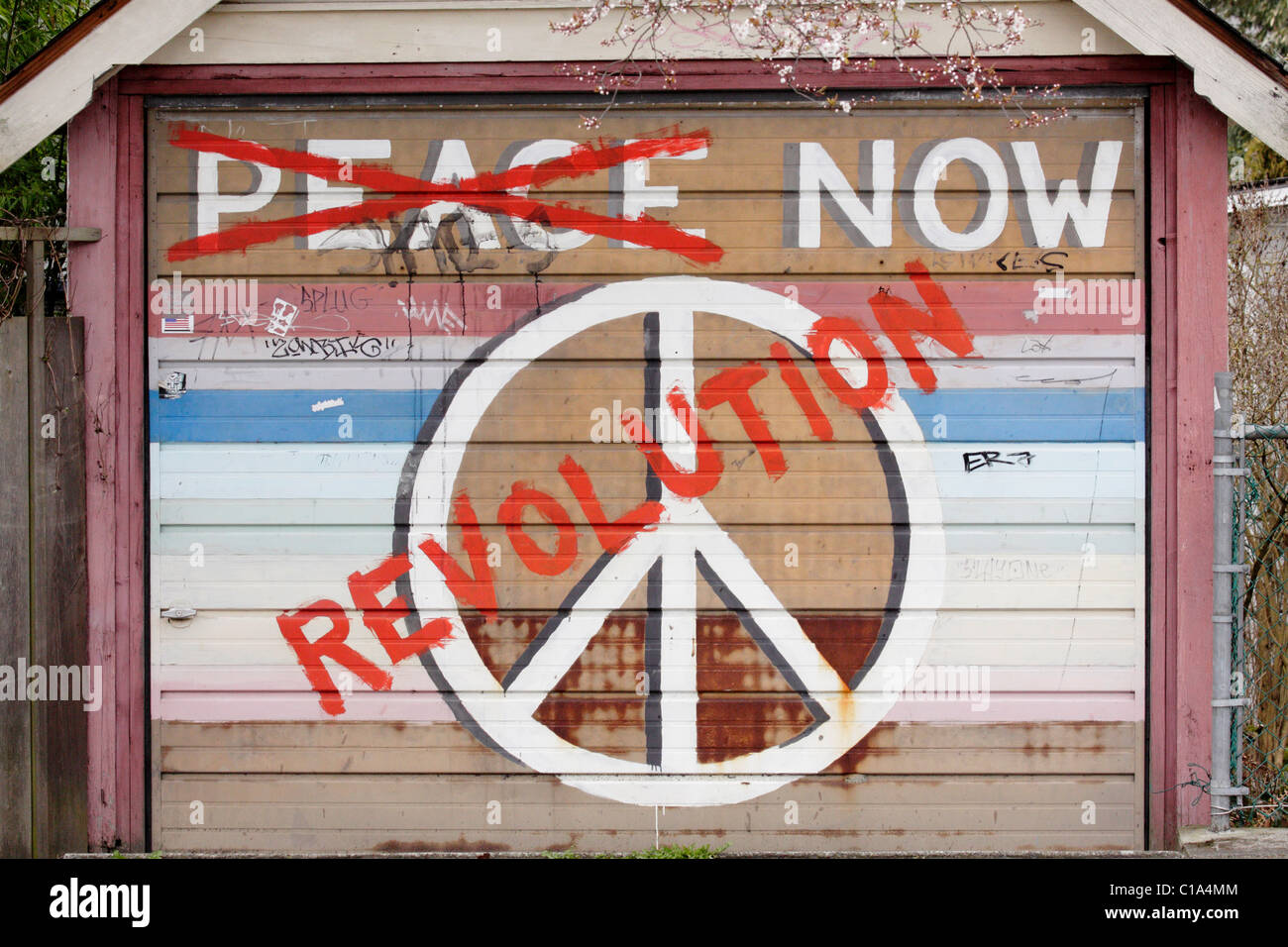 La pace e la rivoluzione segno dipinto graffiti sulla porta di garage-Victoria, British Columbia, Canada. Foto Stock