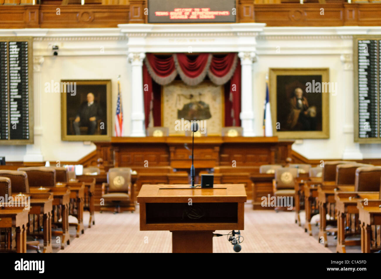 Pulpito dei relatori della Camera della Capitale dello Stato del Texas ad Austin | AUSTIN, Texas — Il pulpito dei relatori si trova nel corridoio centrale della camera della Camera dei rappresentanti del Texas nella Capitale dello Stato del Texas, con il podio, le schede di votazione elettronica e i ritratti storici disposti dietro di esso. Le schede illuminate che affiancano il podio mostrano in tempo reale il voto in corso di ogni membro, un sistema che permette a tutti i 150 rappresentanti di registrare una votazione in pochi secondi. Foto Stock