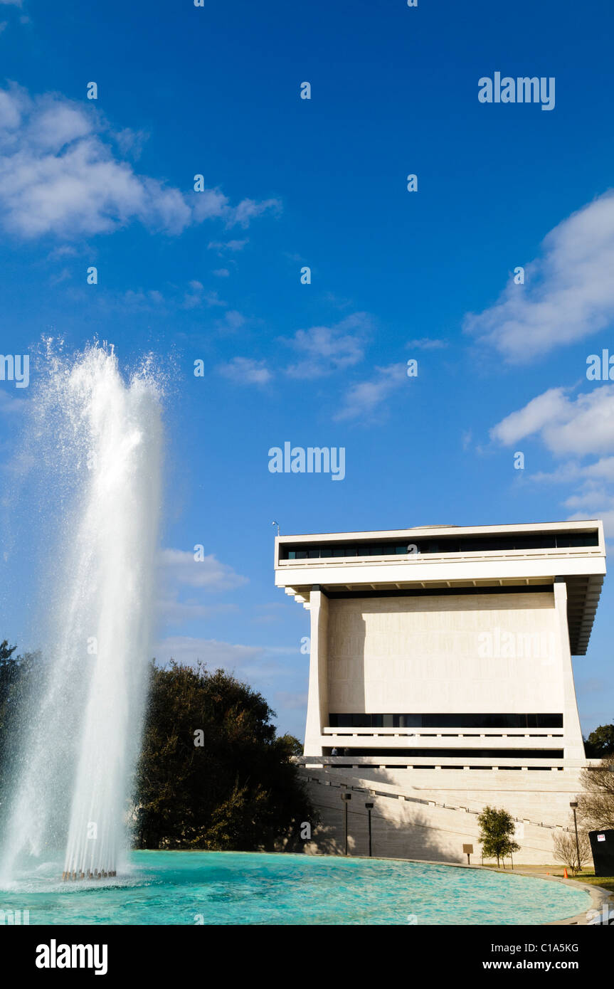 Fontana della Biblioteca LBJ Primo Piano Austin Texas Inverno | AUSTIN, Texas — Una composizione verticale ravvicinata posiziona la fontana della piazza contro la facciata in travertino della Biblioteca e Museo LBJ, la vasca turchese che riempie il telaio inferiore mentre la corona in cemento a sbalzo di Gordon Bunshaft domina lo sfondo. Dedicata nel 1971, la biblioteca gestita da NARA contiene circa 45 milioni di pagine di documenti dell’amministrazione Johnson, la pietra angolare di uno dei presidenze più ampiamente documentate nella storia americana. Foto Stock